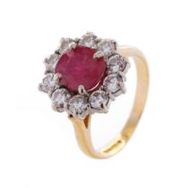 An 18ct yellow gold ruby and diamond cluster ring, with central oval-cut ruby and border of ten