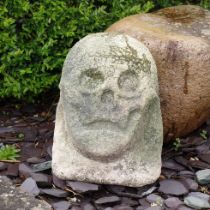 Antique Carved Stone Head in the style of a skull weathered with signs of age and wear an unusual