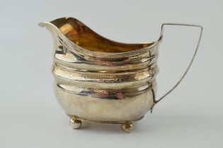 George III silver cream jug, engraved decoration, sat on four ball feet, London 1809, 102.0 grams.
