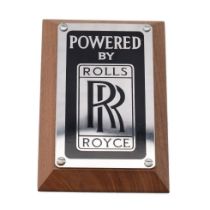 An original 'Rolls-Royce' (Powered By) badge mounted on factory American black walnut. 15cm x 10cm x