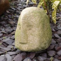 Antique carved stone head weathered with distinctive nose, freestanding, 26cm tall. The head is