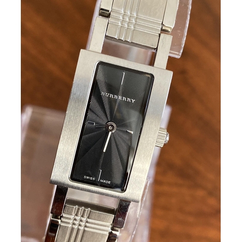 A ladies Burberry fashion watch with Swiss quartz movement. Black rectangular dial with applied