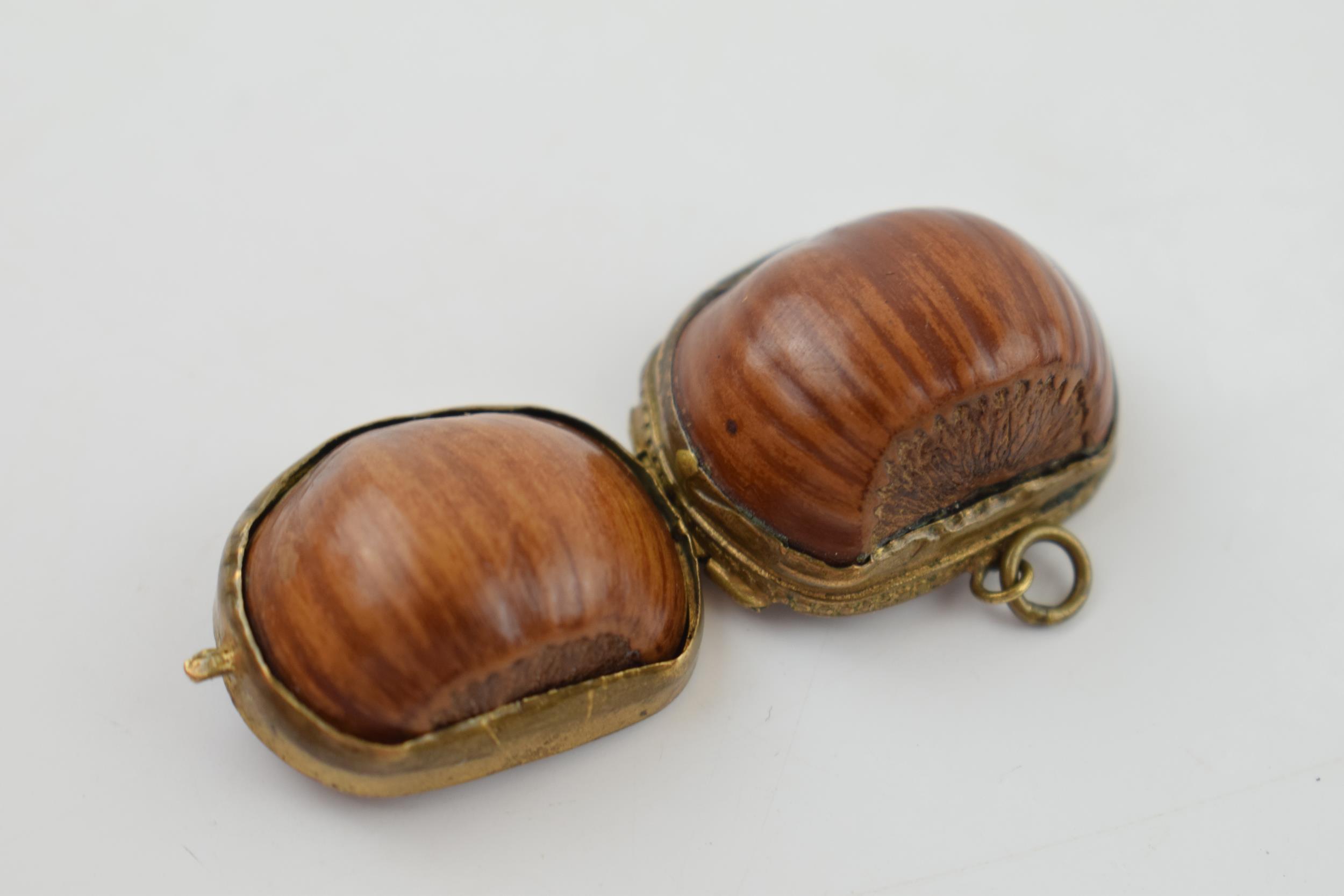 A miniature purse made form a hazelnut shell with brass hinge and mount. 2.5cm. - Image 4 of 4