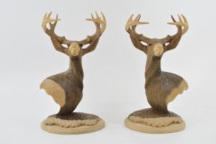 A pair of contemporary highly detailed carved softwood busts in the form of highland stags,
