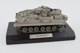 A pewter 'Warrior' tank on a wooden plinth. Height 8cm.