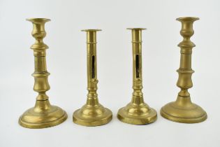 Two pairs of early brass candle sticks with spun bases. One pair benefiting from having height