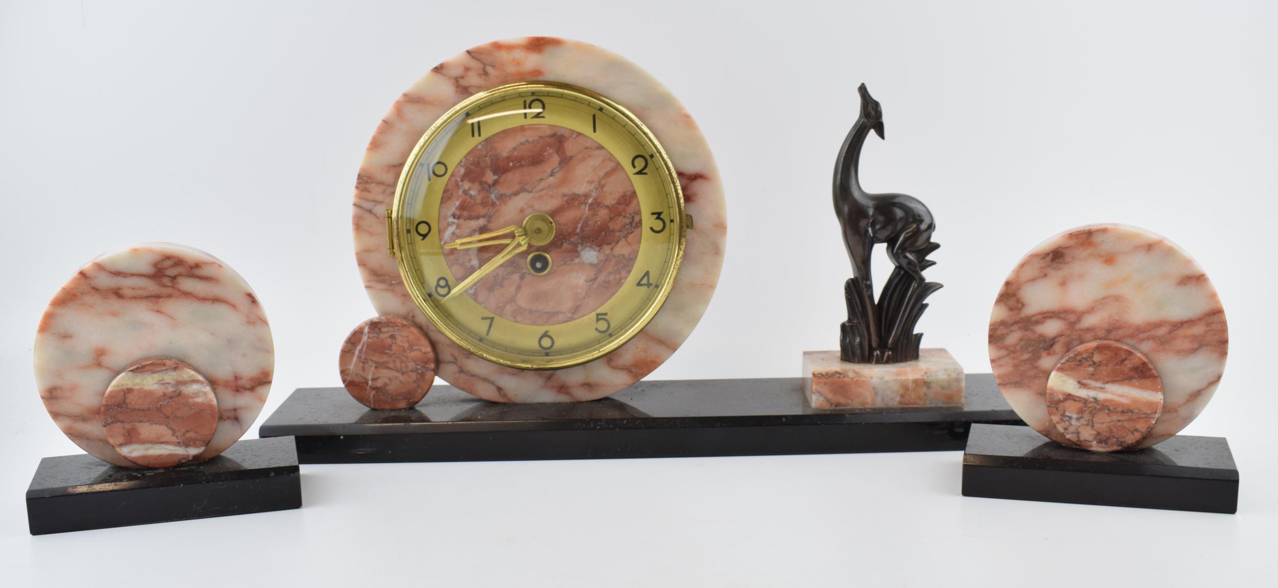 French Art Deco mantle clock, flanked by a gazelle, with garnitures, 42cm long.