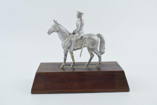 A pewter military man on horse back on wooden base. Height 20cm. With damages to sword. Part is