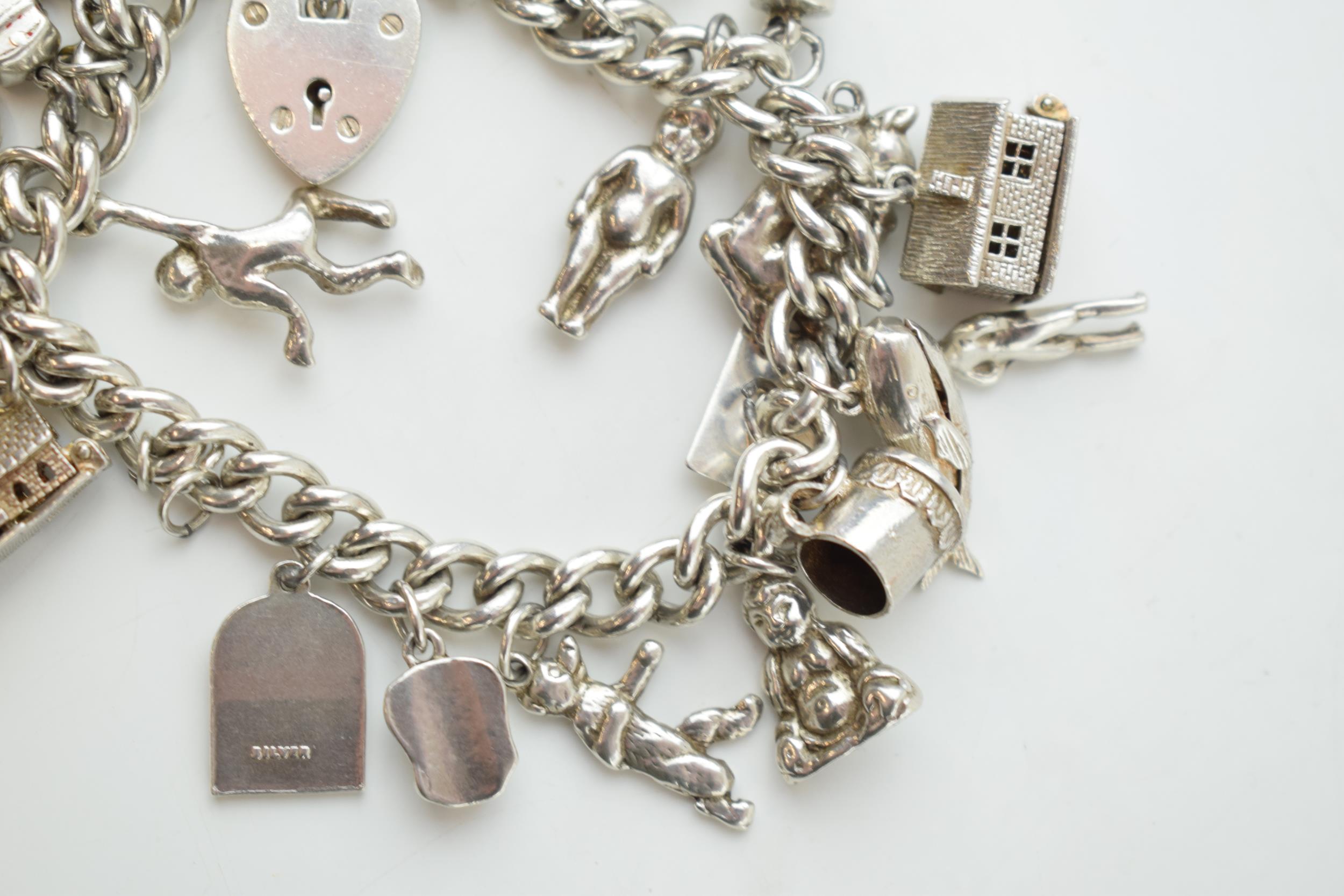 Silver charm bracelet with a church, a bear, people, a tankard and others, 81.6 grams. - Image 2 of 4