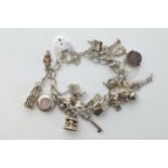 Silver charm bracelet with a poodle, a chalet, a grinder, a Sodastream and others, 78.5 grams.