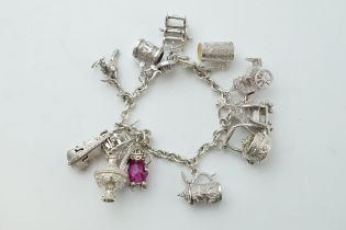 Silver charm bracelet with a teapot, a tankard, a cello, a throne and others, 65.0 grams.