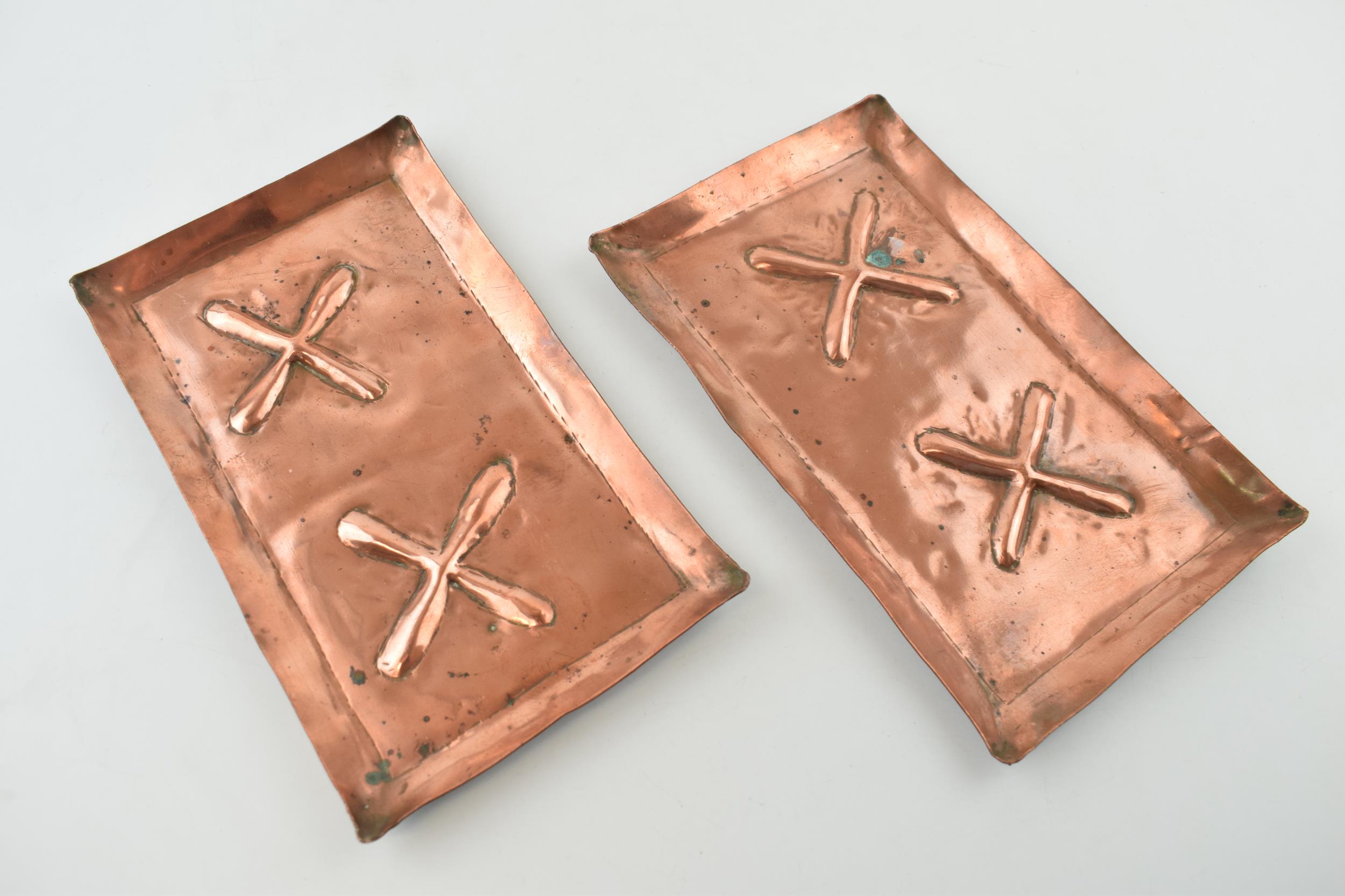 A pair of copper Arts and Crafts rectangular trays with embossed design and raised edges, 19.5cm x