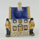 Prattware money box in the form of a house with two figures either side. Height 12.5cm.