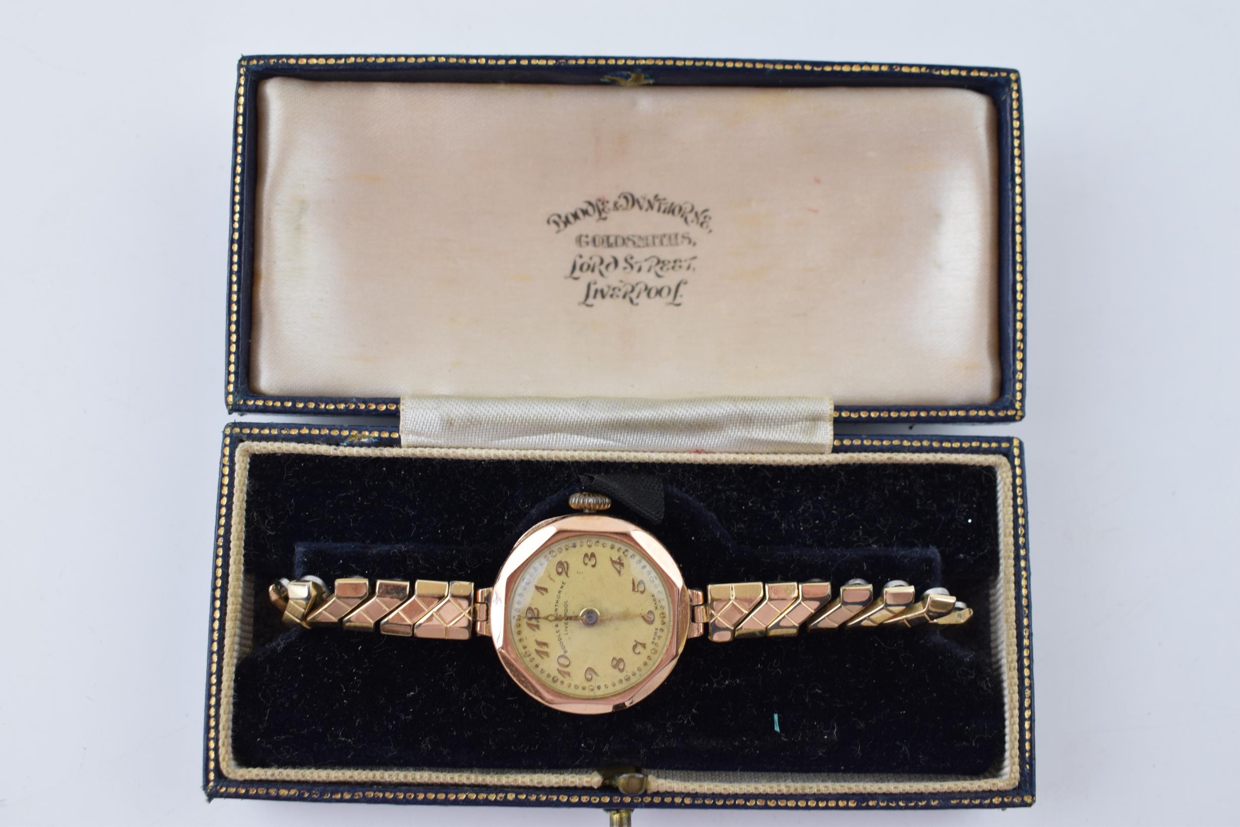 9ct gold ladies cocktail watch in original retailers box 'Boodle & Dunthorne' on metal bracelet.