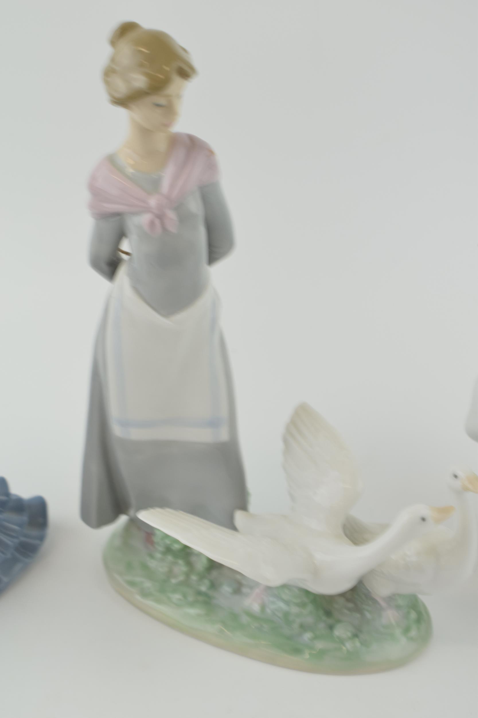 A trio of figures to include a Lladro girl 4820 with a Nao girl with geese and a girl in a frilly - Image 3 of 5
