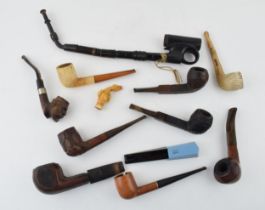 An interesting collection of pipes to include clay pipes, carved wooden heads, early plastic /