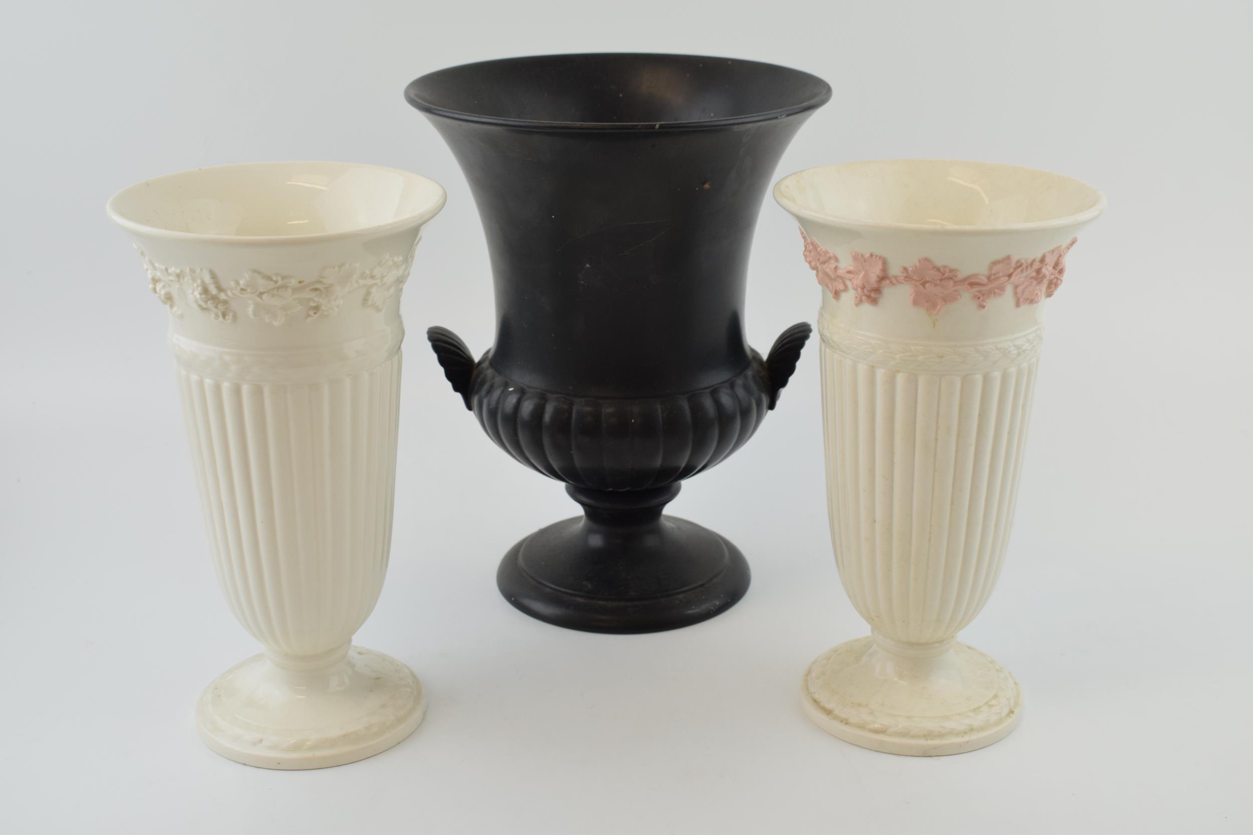 A pair of Wedgwood Queensware trumpet vases, 22cm tall, one pink on white (hole drilled to base),