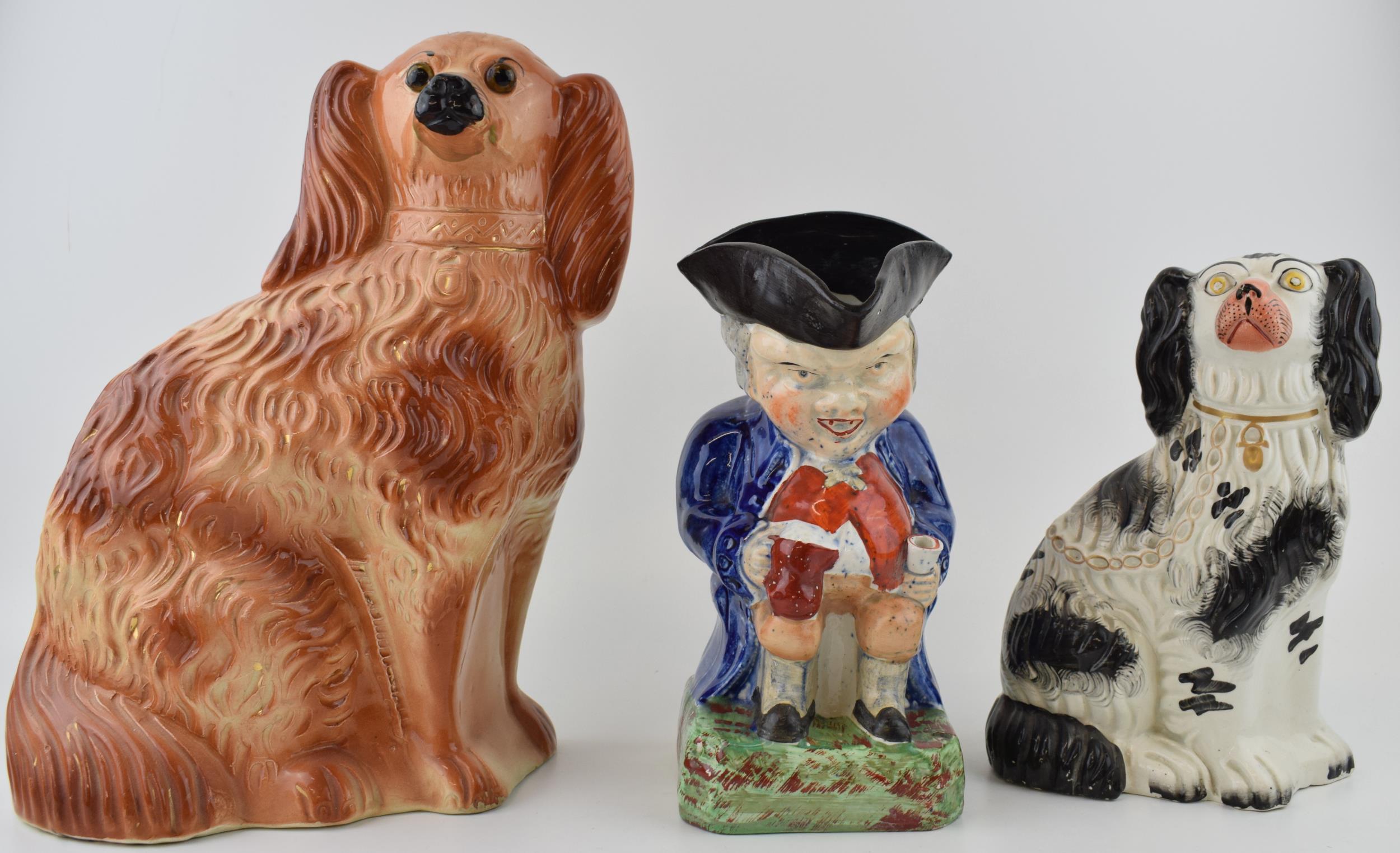 A group of Victorian Staffordshire dog Figures, including a black and white spaniel, a brown spaniel