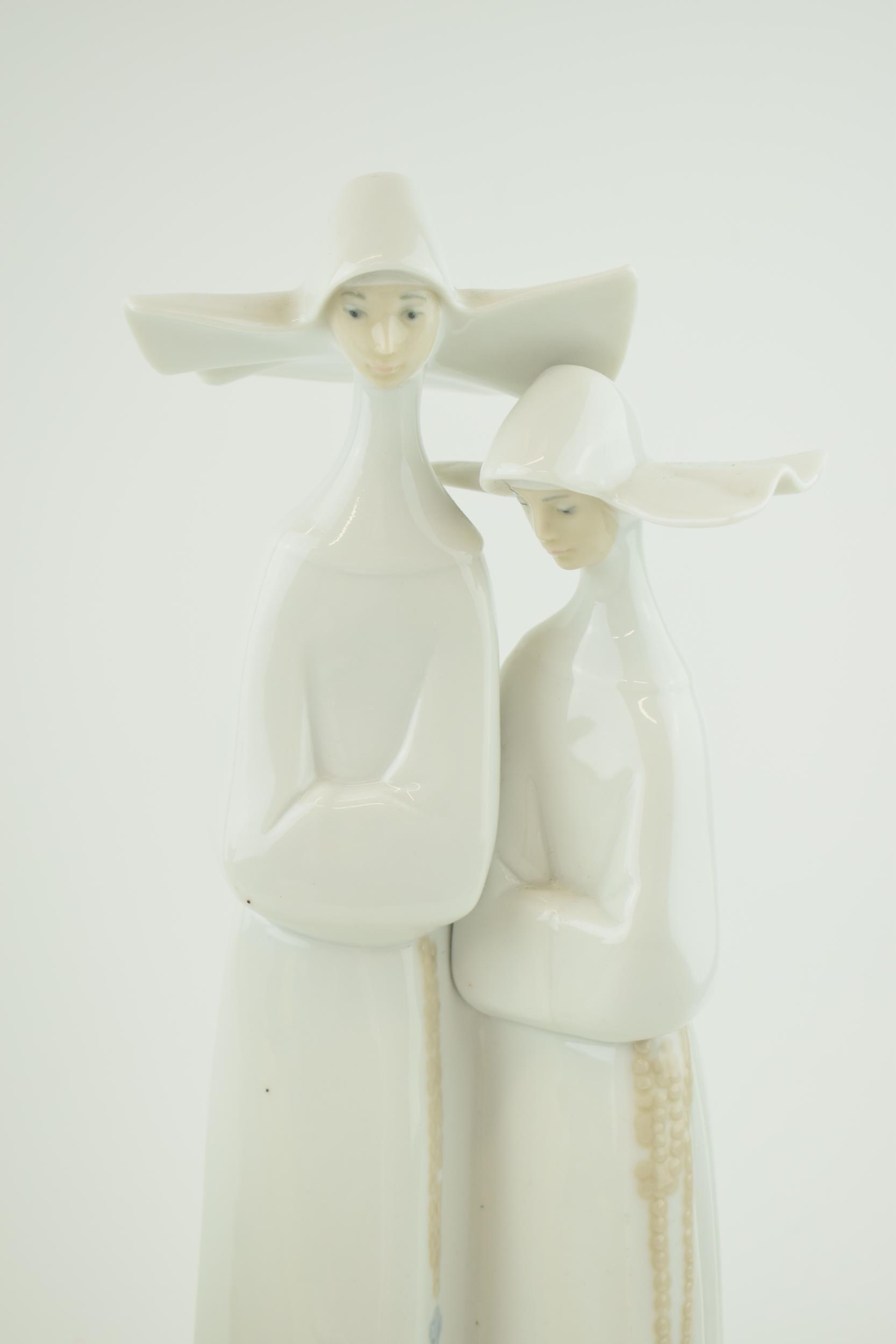 A Lladro figure of two nuns, 33cm tall, a Nao girl with a puppy and a Royal Doulton Follow Me figure - Image 2 of 3