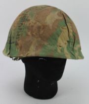 American Vietnam era helmet and camo cover, with liner. Various black ink graffiti to camo cover