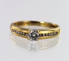 18ct yellow gold diamond solitaire ring, one round brilliant cut approx. 0.33ct, flanked with