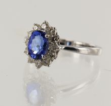 White gold (tests 18ct) diamond and tanzanite cluster ring, violet-blue oval tanzanite approx. 1.