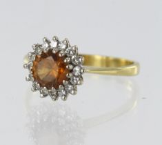 Yellow gold (tests 18ct) diamond and zircon cluster ring, orange zircon measures 6.5mm, surrounded