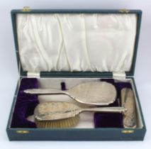 Good quality silver backed three piece boxed dressing-table set comprising hand mirror, hairbrush