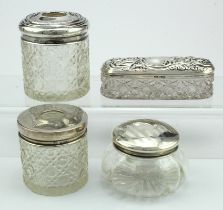 Four silver topped glass items comprising three desk tidies and one rouge pot - all bear British