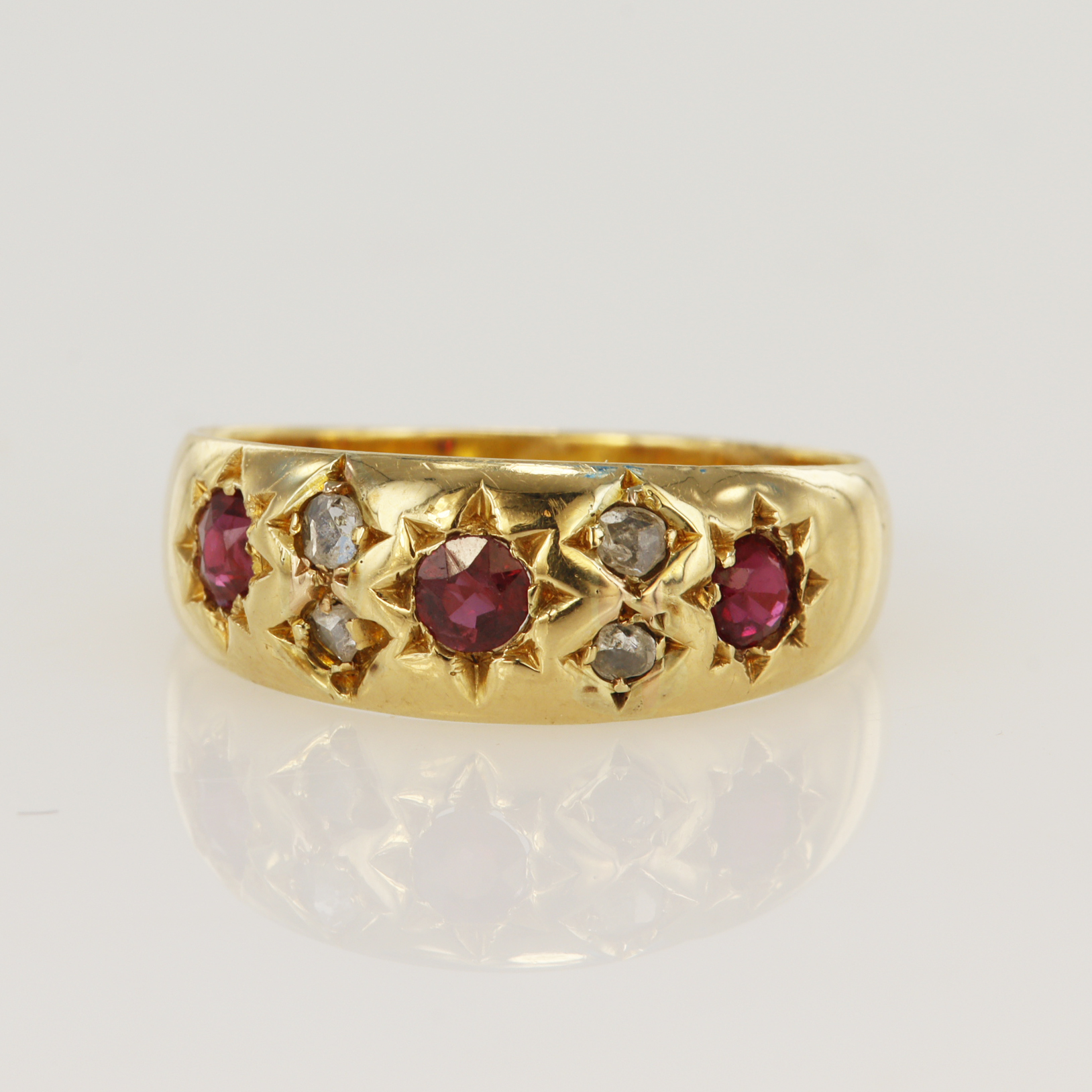 18ct yellow gold Edwardian diamond and ruby gypsy ring, set with three round rubies, principle