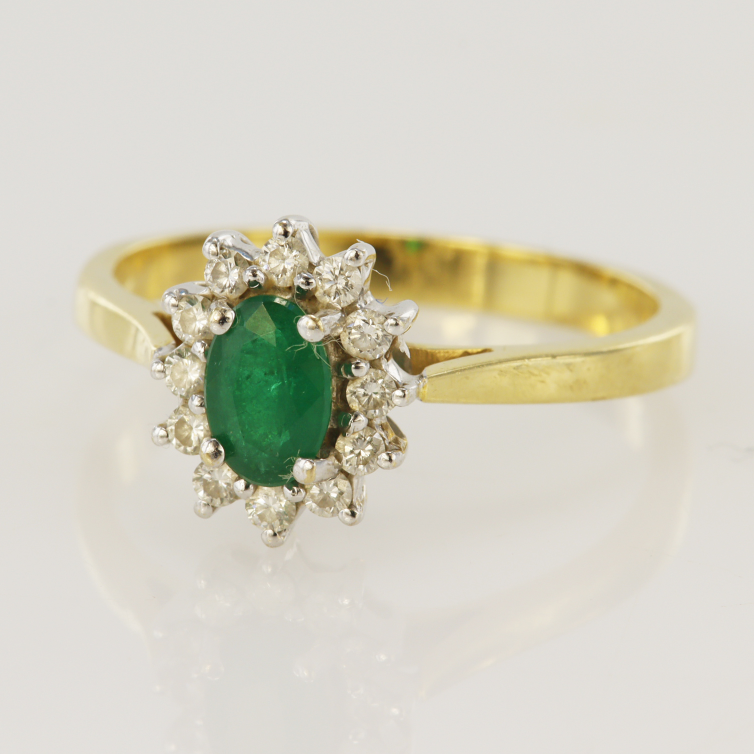 18ct yellow gold diamond and emerald cluster ring, one oval emerald measures approx. 6 x 4mm,