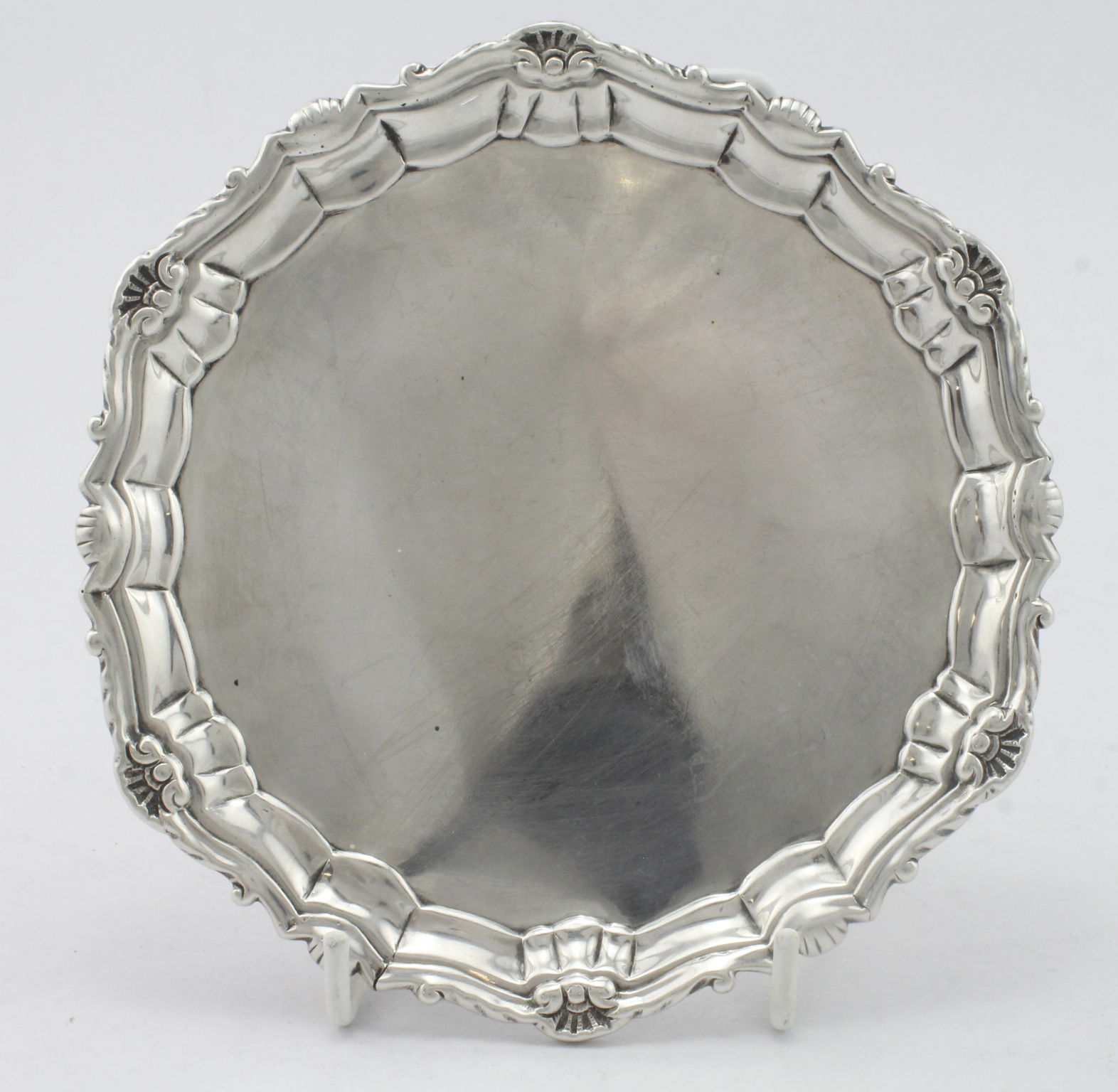 George II silver waiter/card tray with a pie crust surround standing on three scroll feet, two of