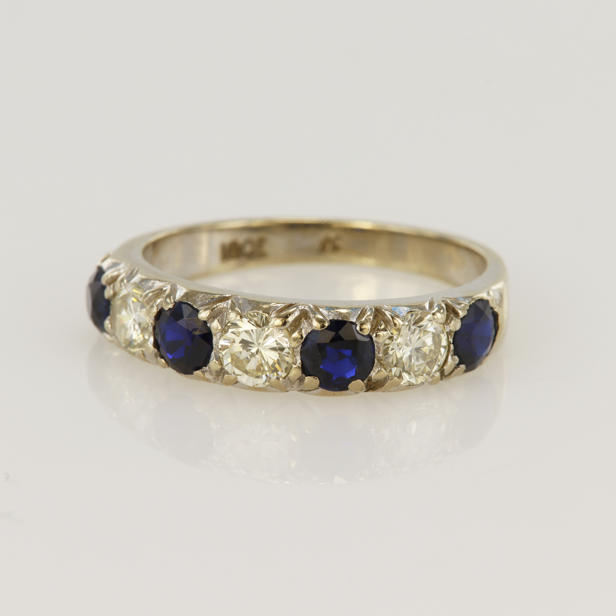 White gold (tests 18ct) diamond and sapphire half eternity ring, three round brilliant cut