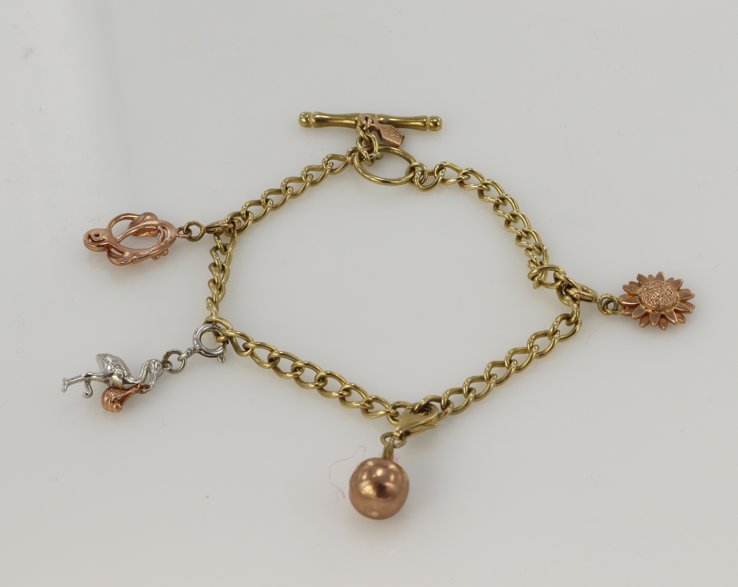9ct yellow Clogau Gold charm bracelet, with four rose gold and white gold Clogau Gold charms, charms