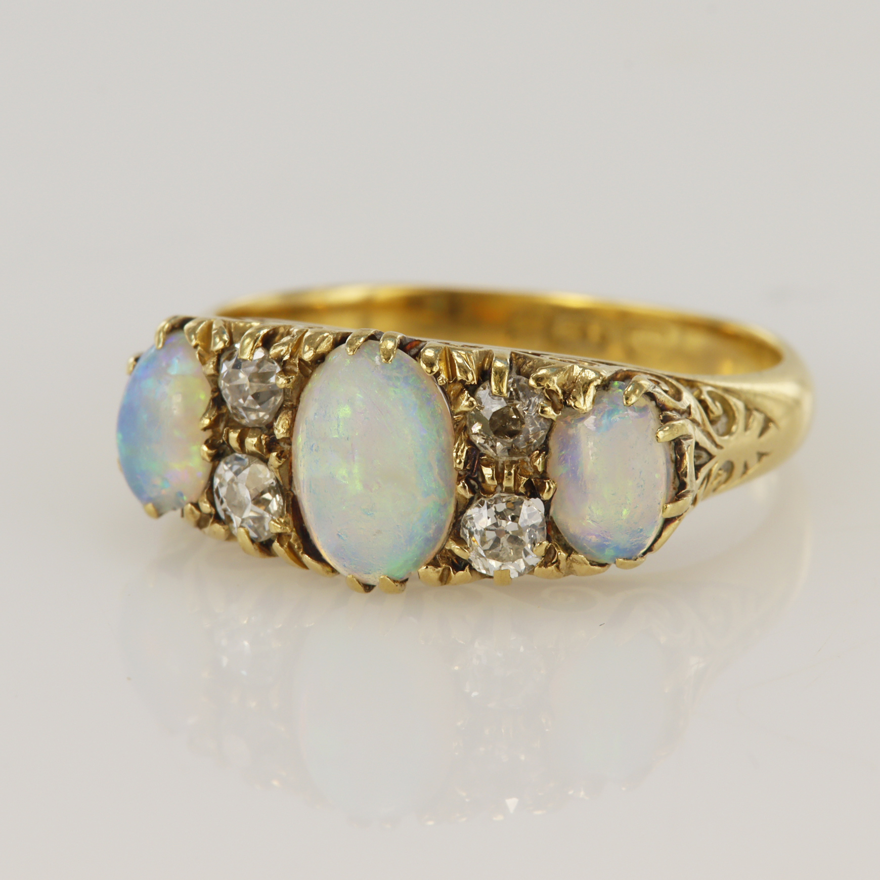 Yellow gold (tests 18ct) antique diamond and opal dress ring, three graduating opals, principle