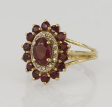 9ct yellow gold diamond and ruby cluster ring, principle oval ruby measures approx. 7 x 5mm,