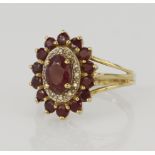 9ct yellow gold diamond and ruby cluster ring, principle oval ruby measures approx. 7 x 5mm,