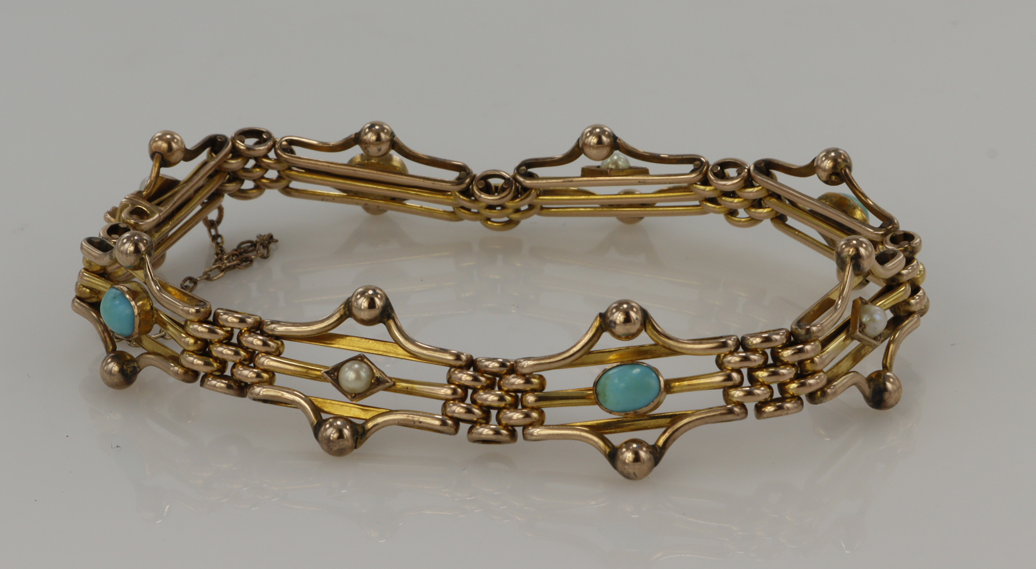 Yellow gold (tests 9ct) turquoise and seed pearl gate bracelet, four turquoise measuring approx. 5 x