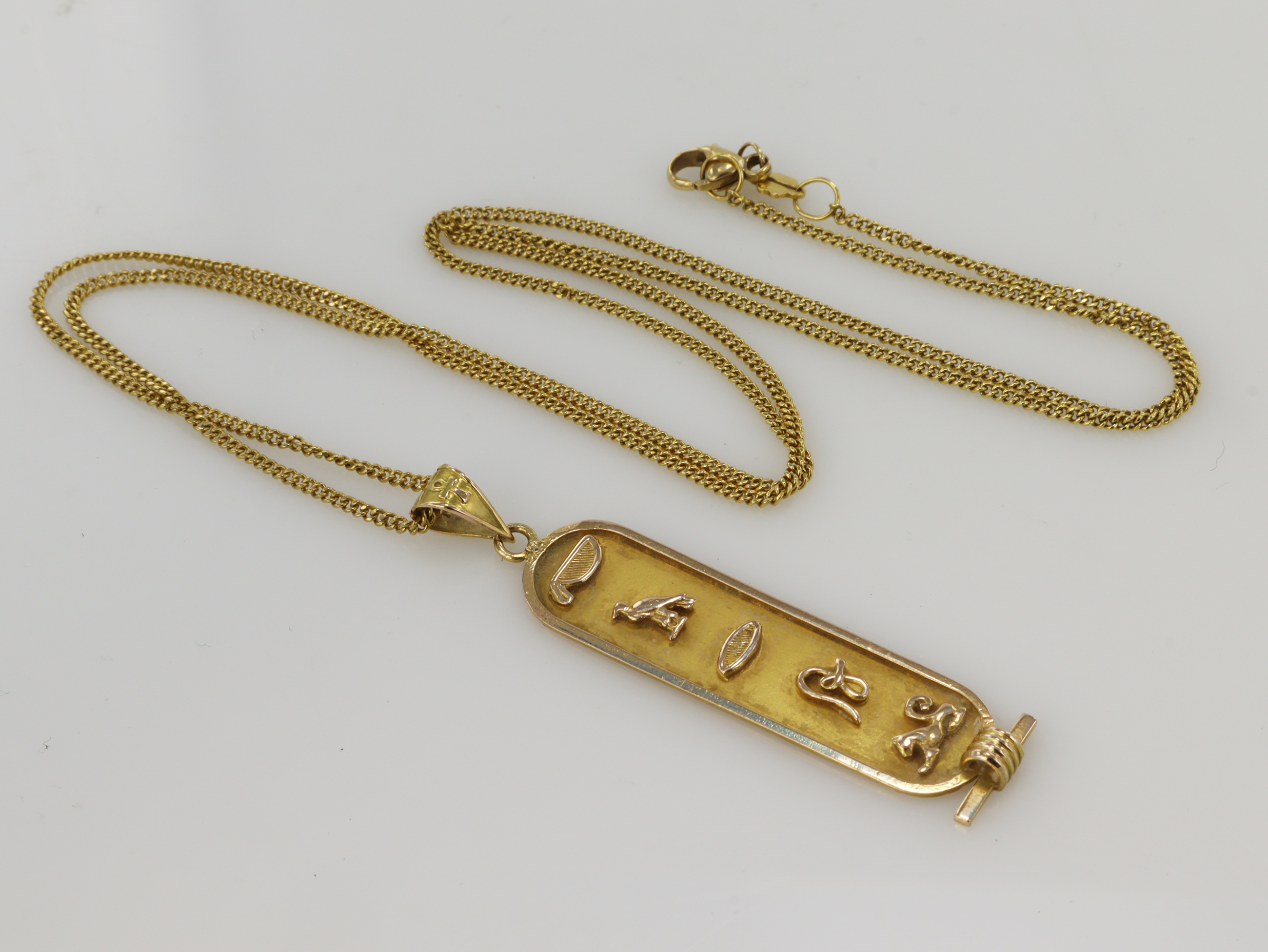 Yellow gold (tests 14ct) Egyptian cartouche pendant, length 50mm, weight 3. Suspended from a