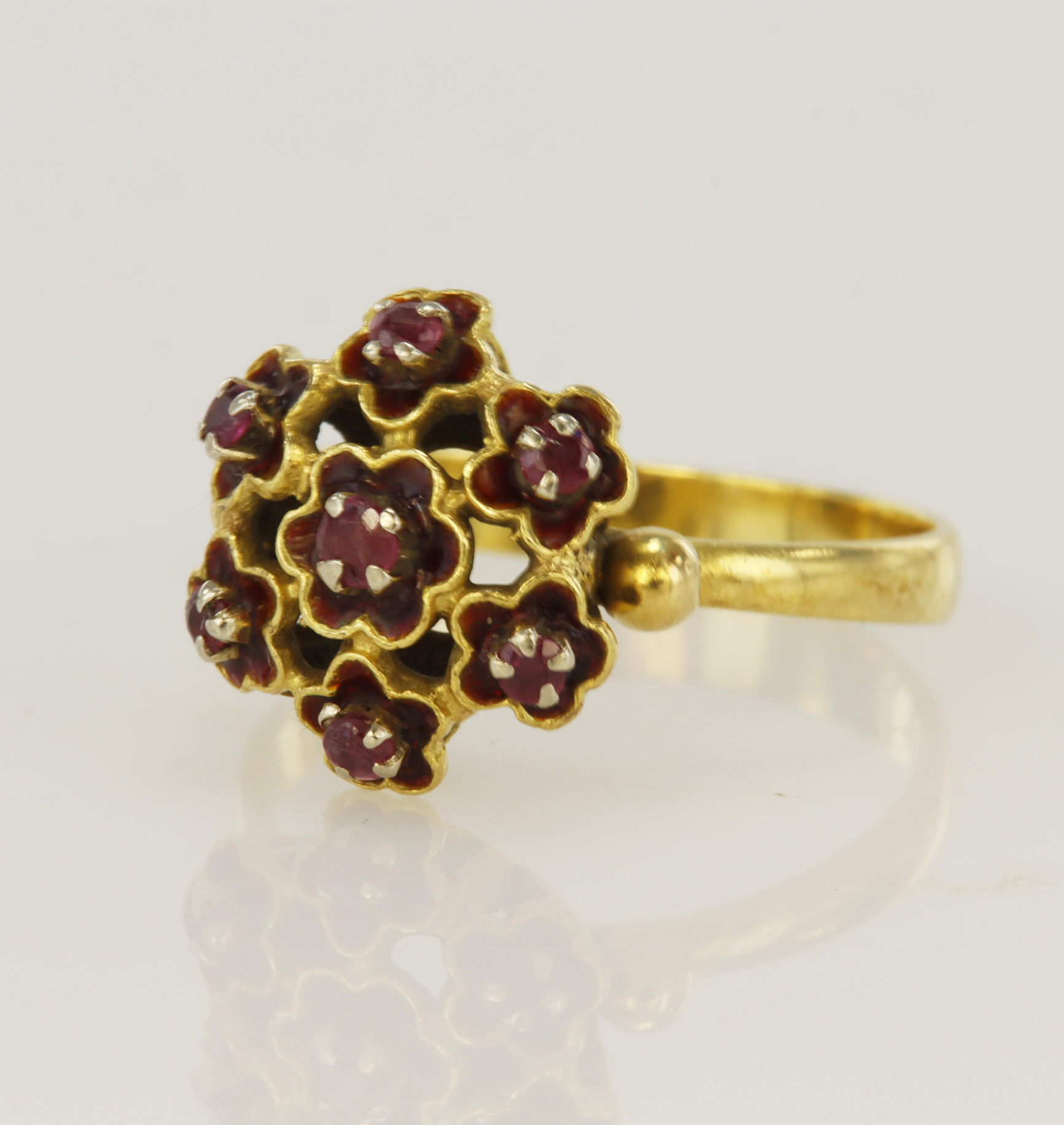 Yellow gold (tests 18ct) ruby floral cluster ring, seven rubies surrounded with red enamel,