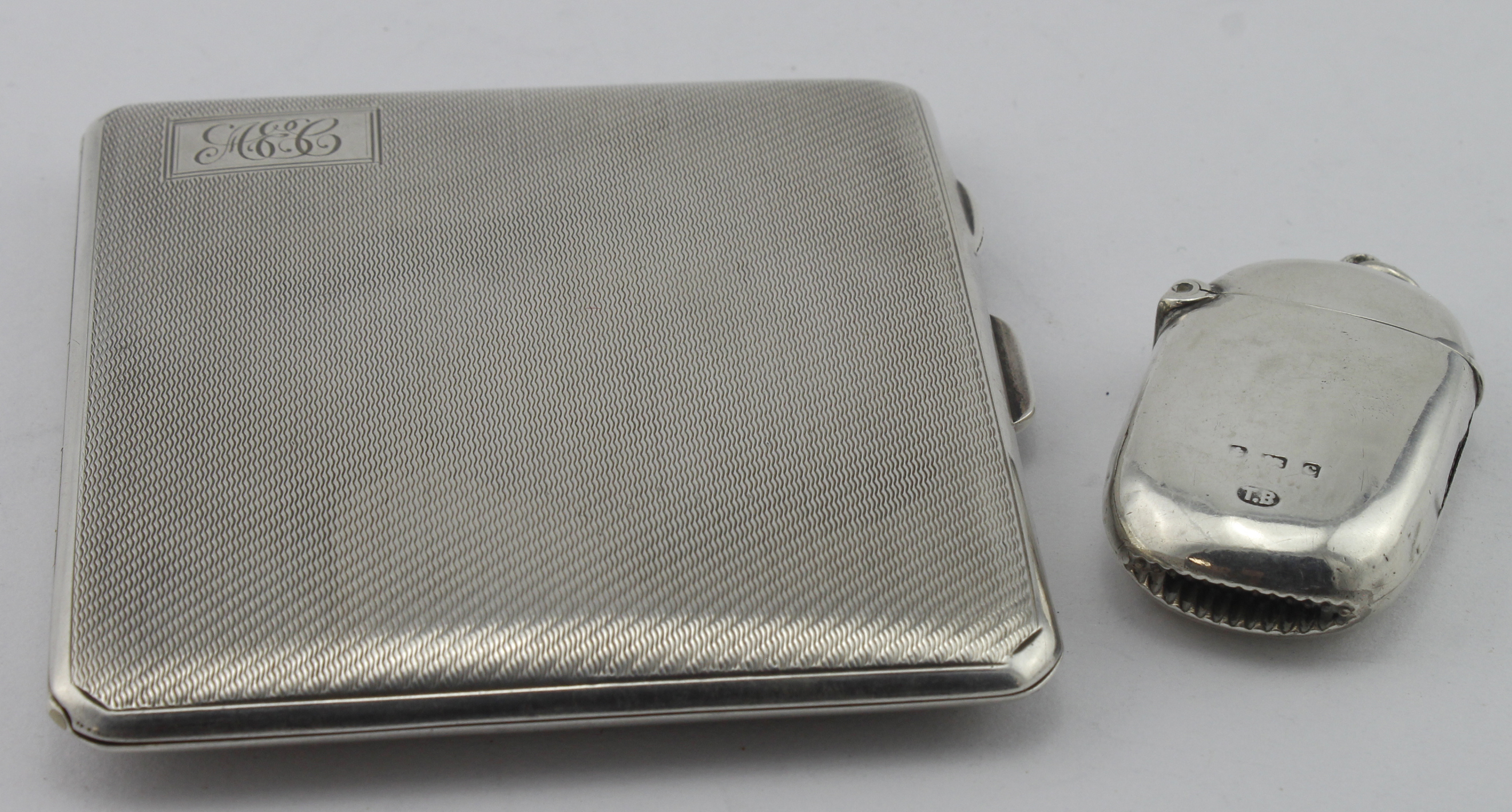 Silver cigarette case & a silver vesta case hallmarked respectively Birm. 1938 and Birm. 1902.