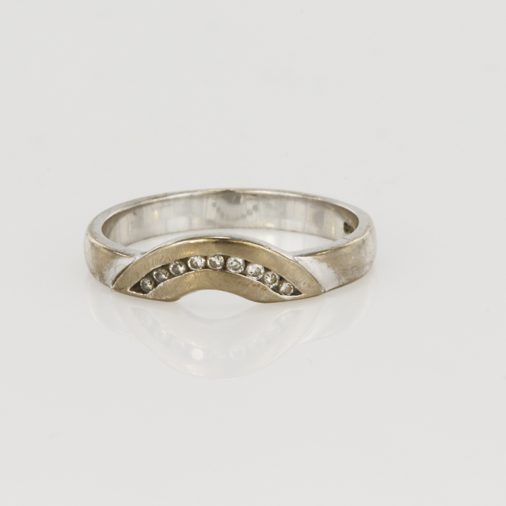 18ct white gold shaped band ring with nine round brilliant cut diamonds in a channel setting,