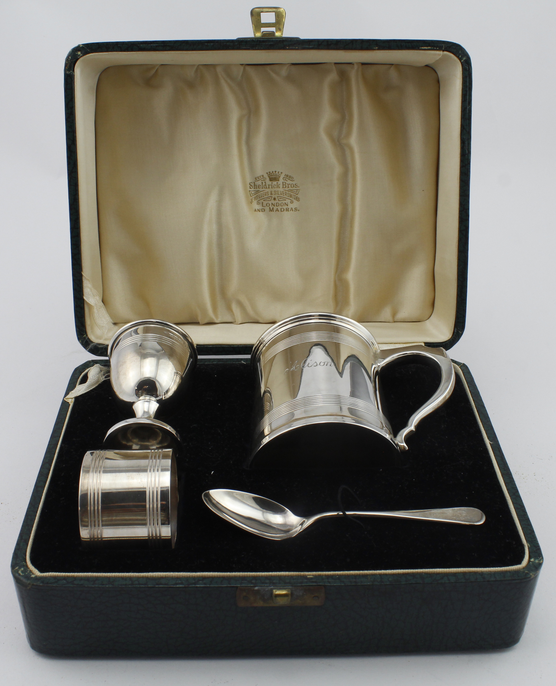 Attractive boxed silver Christening set comprising a mug, napkin ring, egg cup and spoon, all