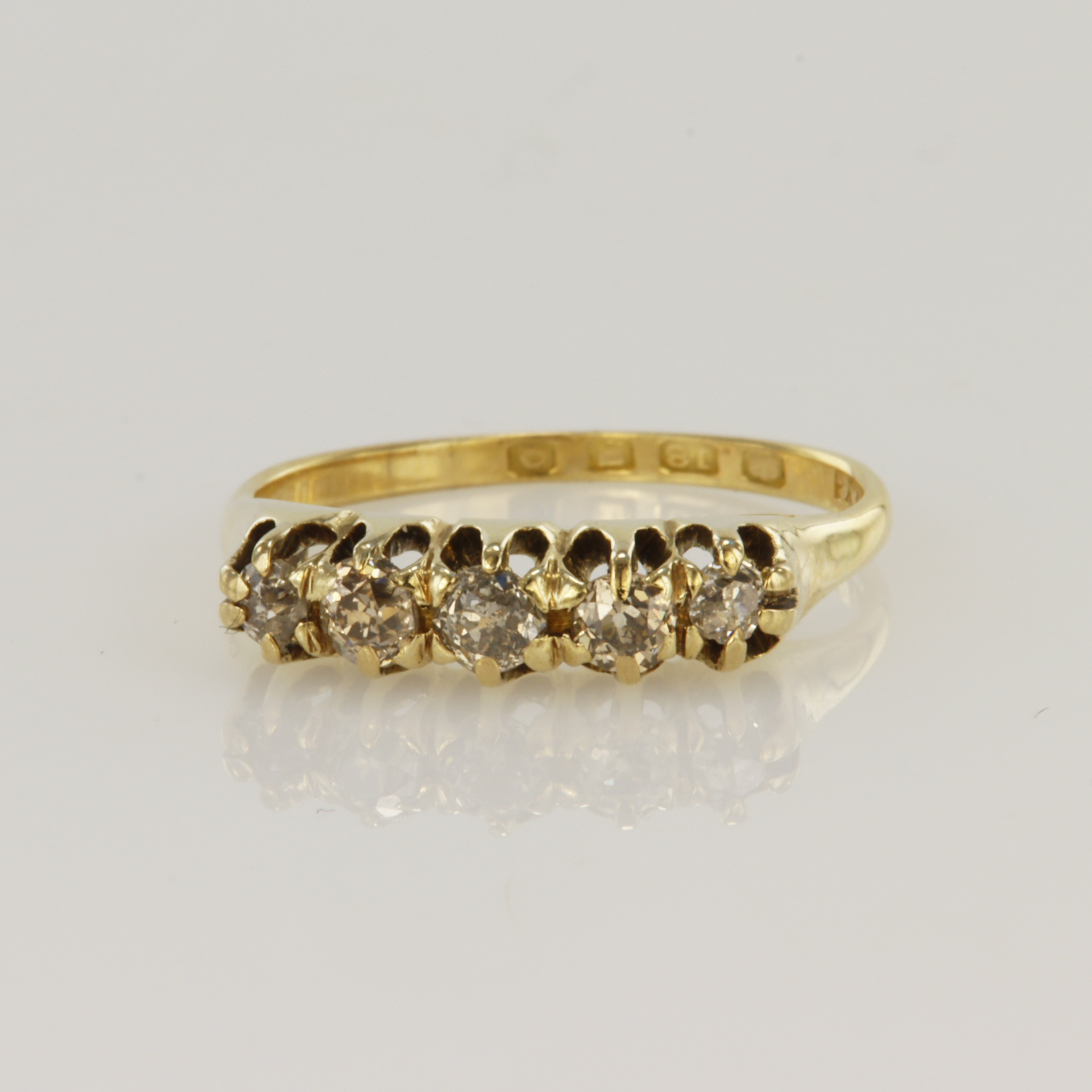 18ct yellow gold diamond ring featuring five round old cut diamonds in raised claw mounts, total