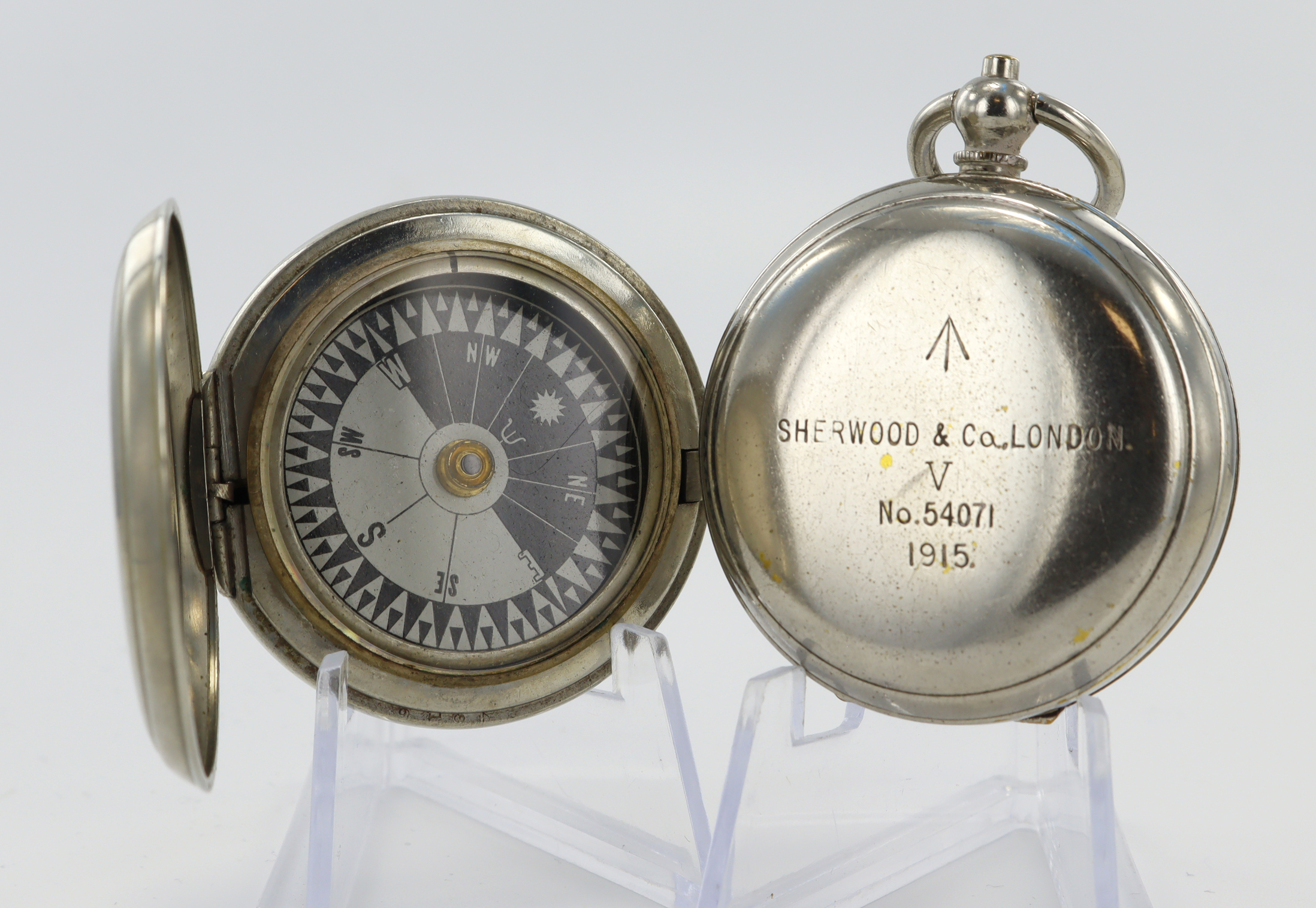 Two British Military Issue nickel cased compasses. One by Dennison dated 1916 with issue markings '↑
