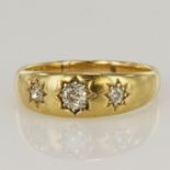 18ct yellow gold flared band ring set with three round old cut diamonds in Gypsy settings, centre