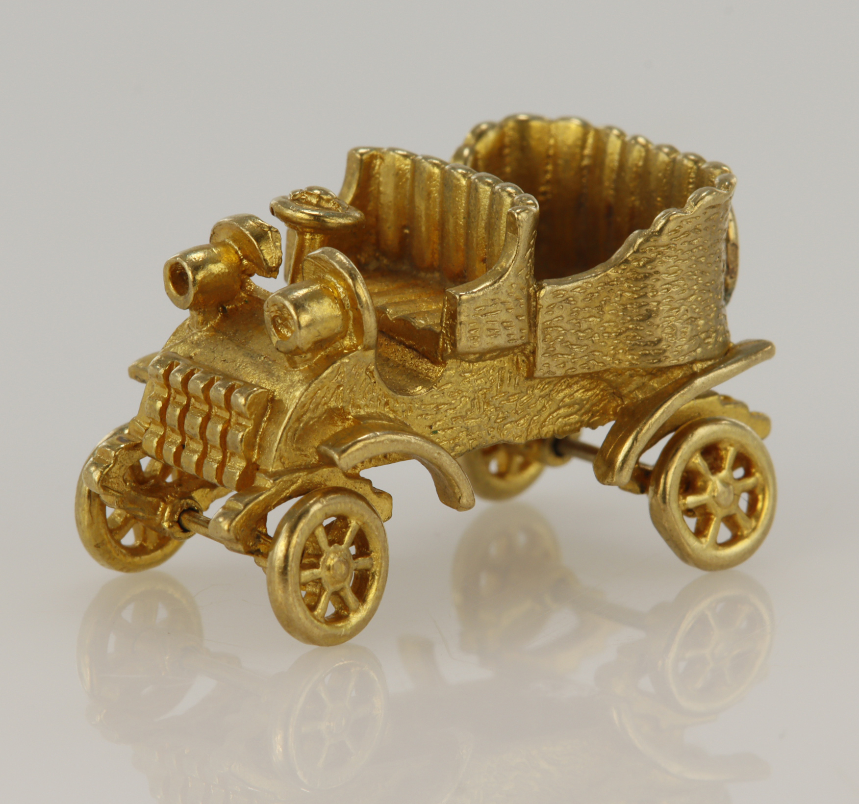 9ct yellow gold articulated vintage car charm, height 15mm, weight 7.9g.