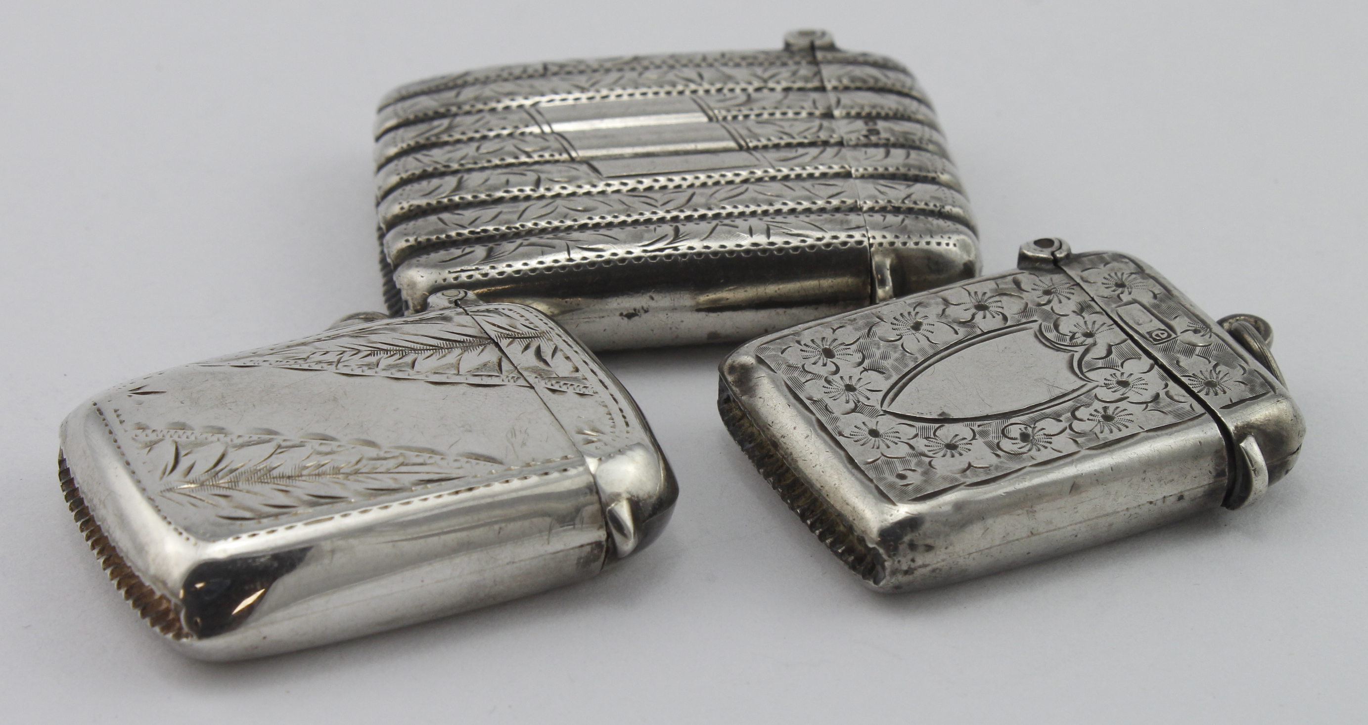Three decorated silver vesta cases, all three hallmarked, respectively for Birm. 1901, 1904 &
