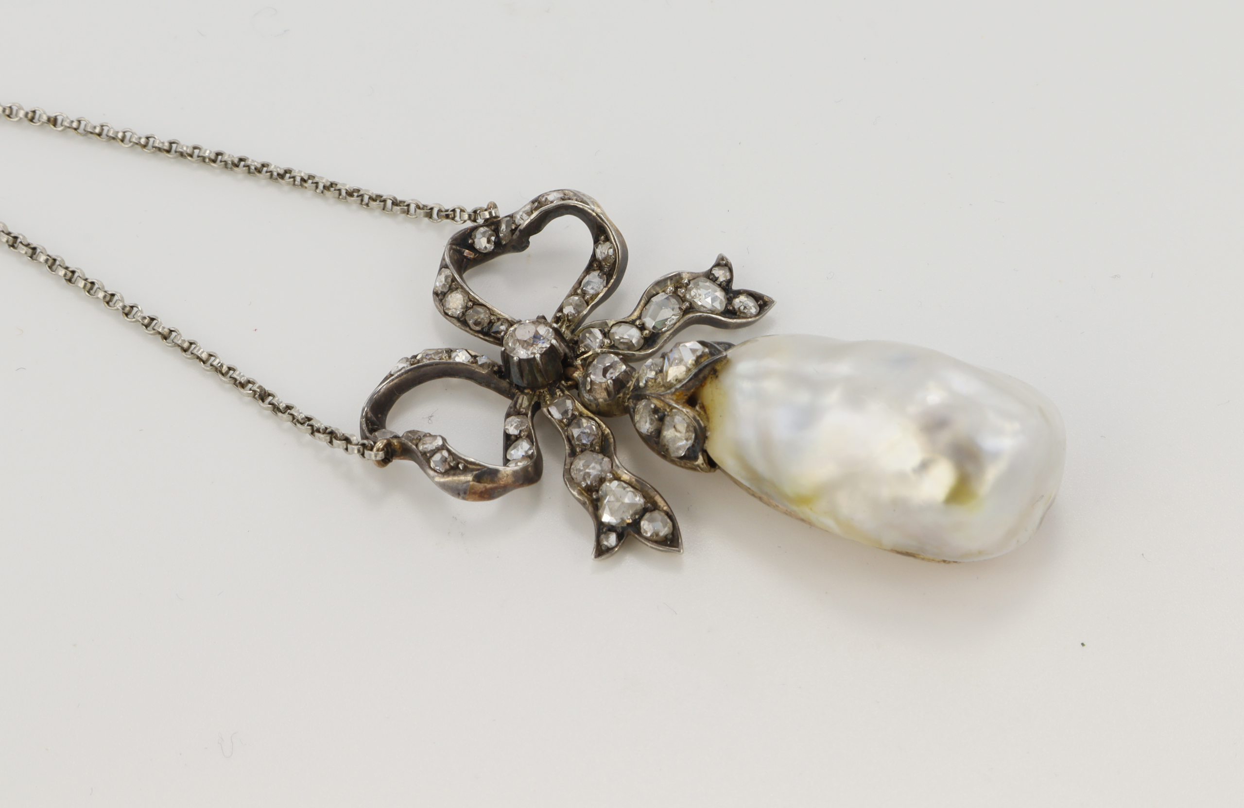 A Victorian diamond and natural saltwater pearl necklace, (tests 8ct) gold backed silver bow set - Image 2 of 2