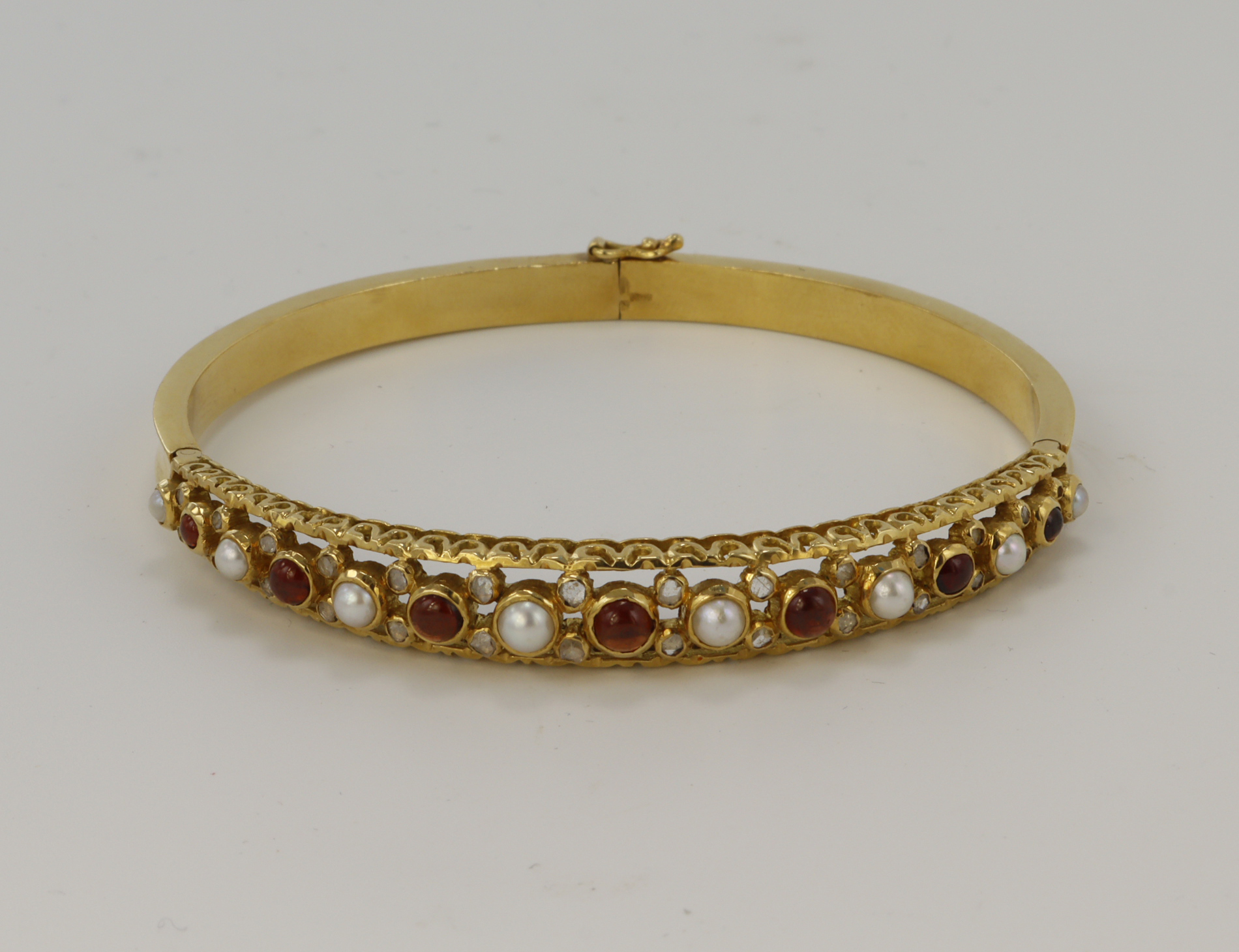 18ct yellow gold diamond, garnet and cultured pearl bangle, seven graduating cabochon garnets
